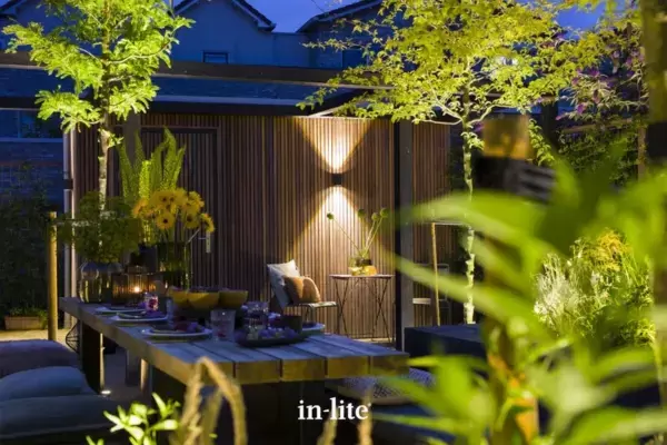 Dutch style garden with alfresco dining space and timber outbuilding, surrounding plants and trees beautifully illuminated by in-lite 12 volt outdoor lights.