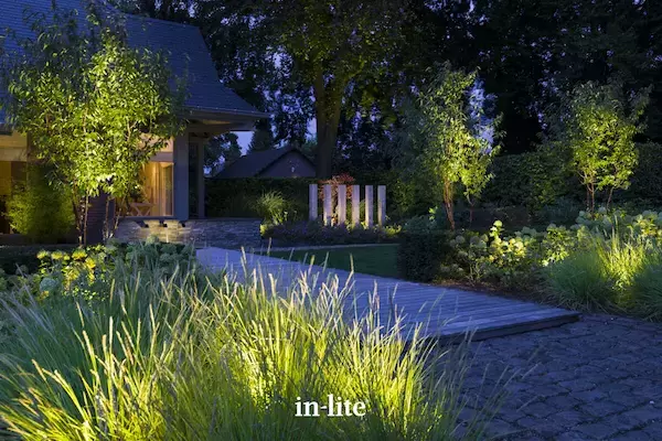 Beautifully illuminated landscape garden with lighting installed and positioned for highlighting trees, borders, grasses, walls and features.