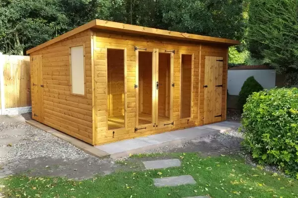 Garden room summer house with additional storage units installed on concrete base foundation in residential garden.