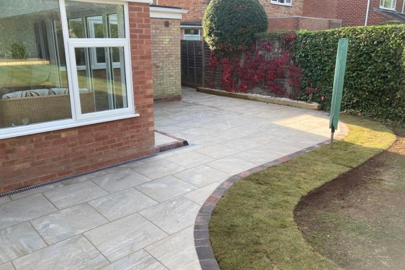 Landscaping works completed in Solihull. Porcelain patio with block edging and step installed. New turf laid along patio block edge.