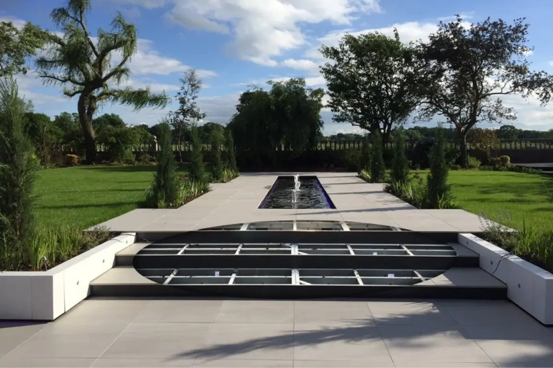 Large countryside landscape garden project with outdoor porcelain patio, steps, walkways and water fountains installed on the iGarden light steel subframe foundation system.