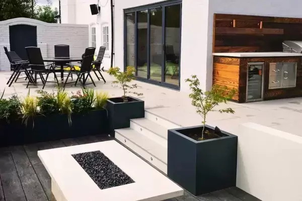 Large terrace sunken patio space with composite decking, grp planters and fire table installed using the iGarden light steel subframe foundation system.