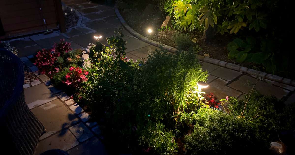 12v outdoor garden lighting installation completed in Solihull. Low voltage outdoor post lights and ground spotlights illuminating plants and features in patio borders - Oakland Group, Outdoor Garden Lighting Design and Installation Services.