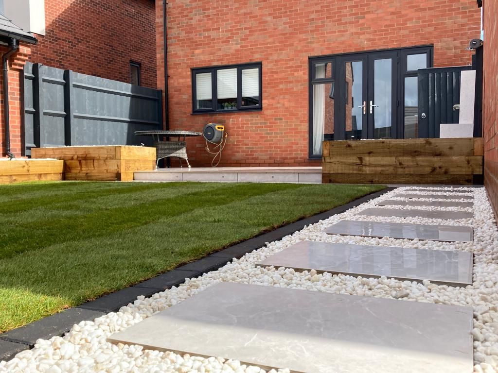 Contemporary, new build home, garden design and build, porcelain patio, porcelain pathway, raised sleeper beds, water feature, low voltage garden lighting, outdoor living space, garden build project, Blythe Valley, Solihull.