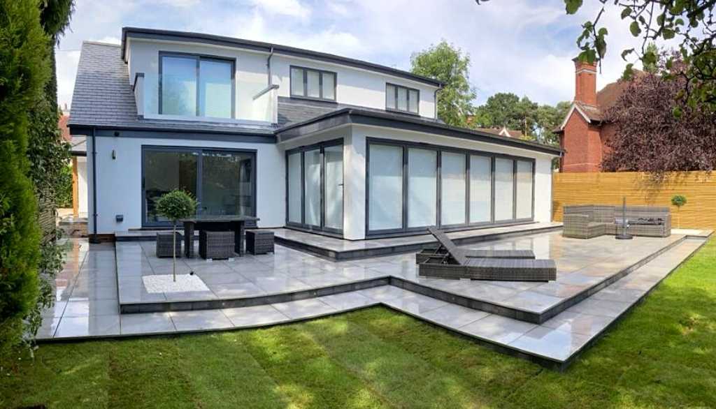 Contemporary new build home extension with porcelain patio terraces for luxury garden outdoor living space in Dorridge, Solihull - Oakland Group. 