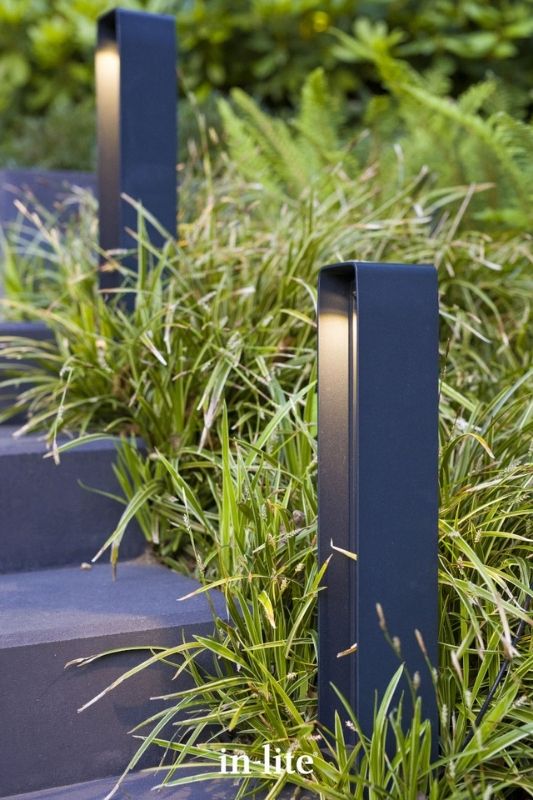 in-lite ACE HIGH DARK 12v outdoor bollard lights, positioned upright in the borders along a garden staircase, illuminating the borders and staircase with a targeted light spread either side of the fixture. Low voltage outdoor garden lights, atmospheric path lighting for ambiance.
