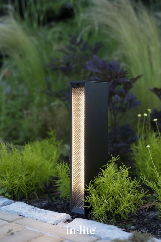 in-lite EVO LOW DARK 12v outdoor bollard light, positioned upright in pathway border, illuminating the pathway with a considerable amount of light without glare. Low voltage outdoor garden lights, atmospheric lighting for ambiance.