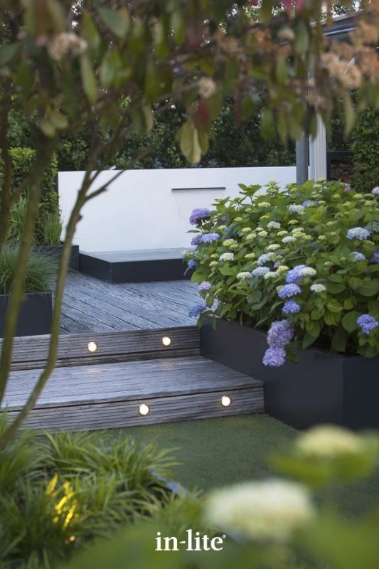 in-lite FUSION 12v outdoor decking lights recessed in deck risers providing an elegant warm white indicative light. Low voltage outdoor garden lights, atmospheric lighting for ambiance.