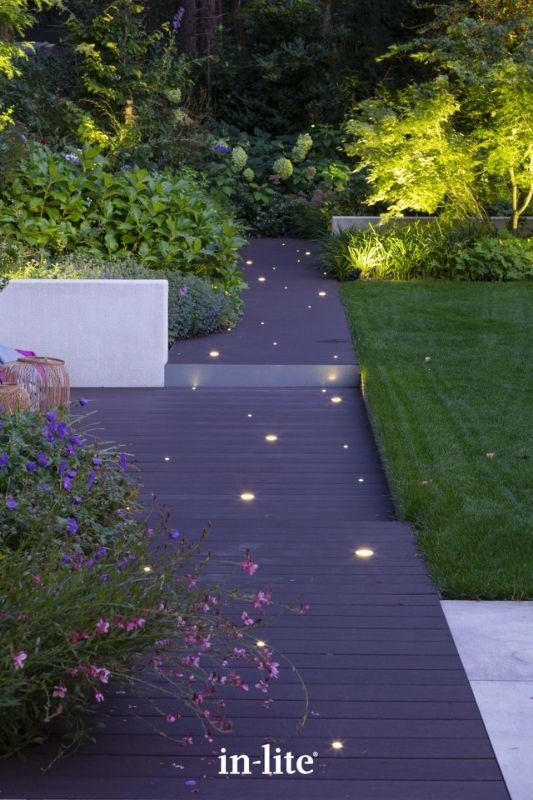 in-lite FUSION and FUSION 22 RVS 12v outdoor decking lights, installed in decking boards, illuminating with a soft ambient glow to provide an indicative starry pattern along the walkway. Low voltage outdoor garden lights, atmospheric lighting for ambiance.