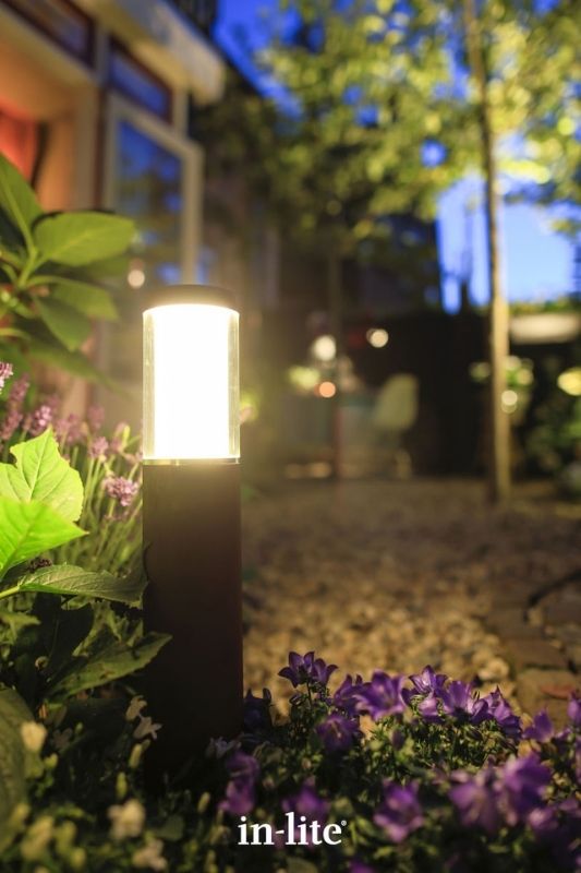 in-lite LIV LOW DARK 12v outdoor bollard light, installed in a path border, illuminating plants with an atmospheric lighting effect all round the border. Low voltage outdoor garden lights, atmospheric lighting for ambiance.