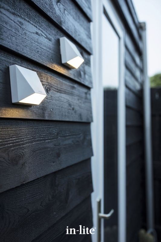 in-lite WEDGE WHITE 12v outdoor wall lights, installed on exterior boards of outdoor garden room, illuminating wall and ground with an indirect, concentrated warm white light. Low voltage outdoor garden lights, atmospheric lighting for ambiance.