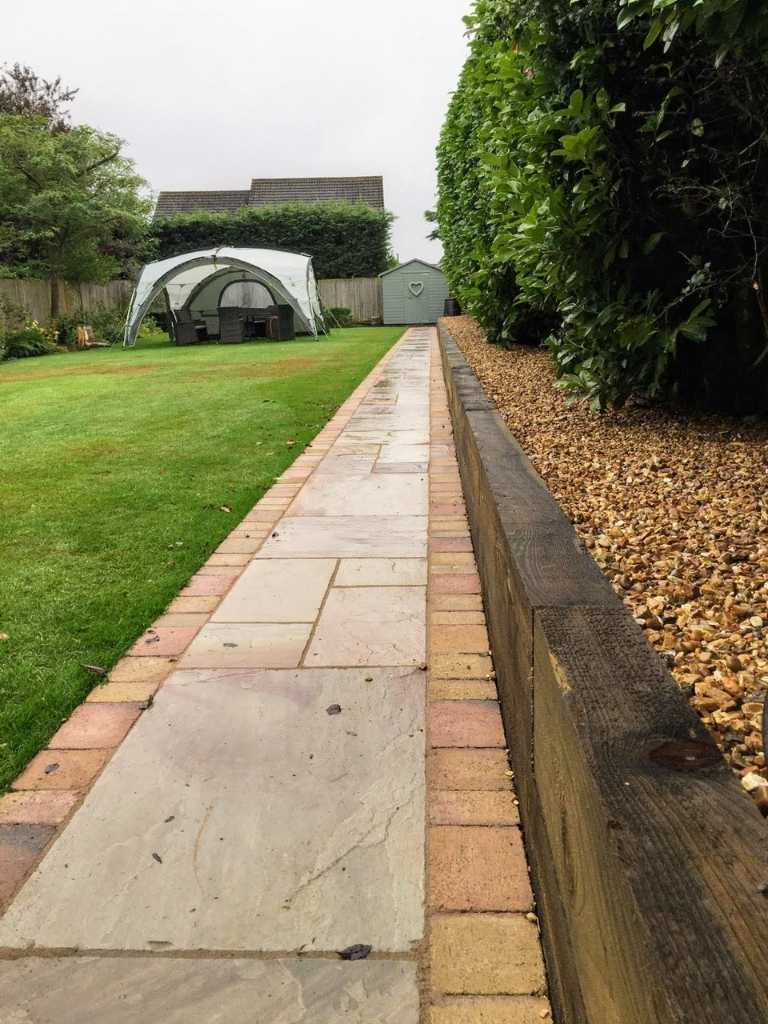 Landscape garden natural stone pathway with block edge border and raised bed built with timber sleepers - Oakland Group.