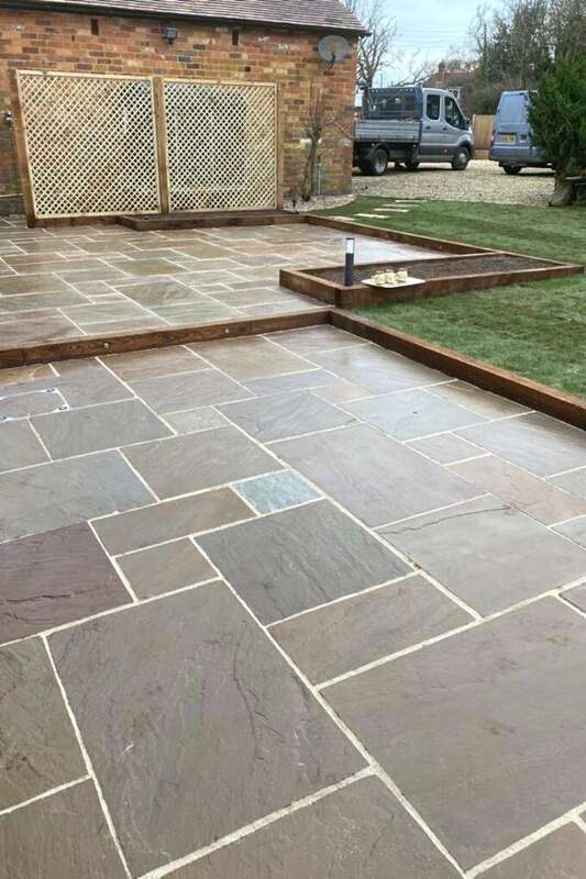 Natural stone paving with timber planting bed borders and integrated 12 volt outdoor lighting installed in garden landscape transformation in Earlswood, Shirley, Solihull - Oakland Group.