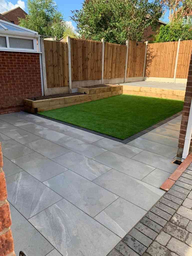 Low maintenance garden with outdoor porcelain terraced patios, artificial lawn and timber sleeper raised planting beds in Kenilworth, Warwickshire - Oakland Group.