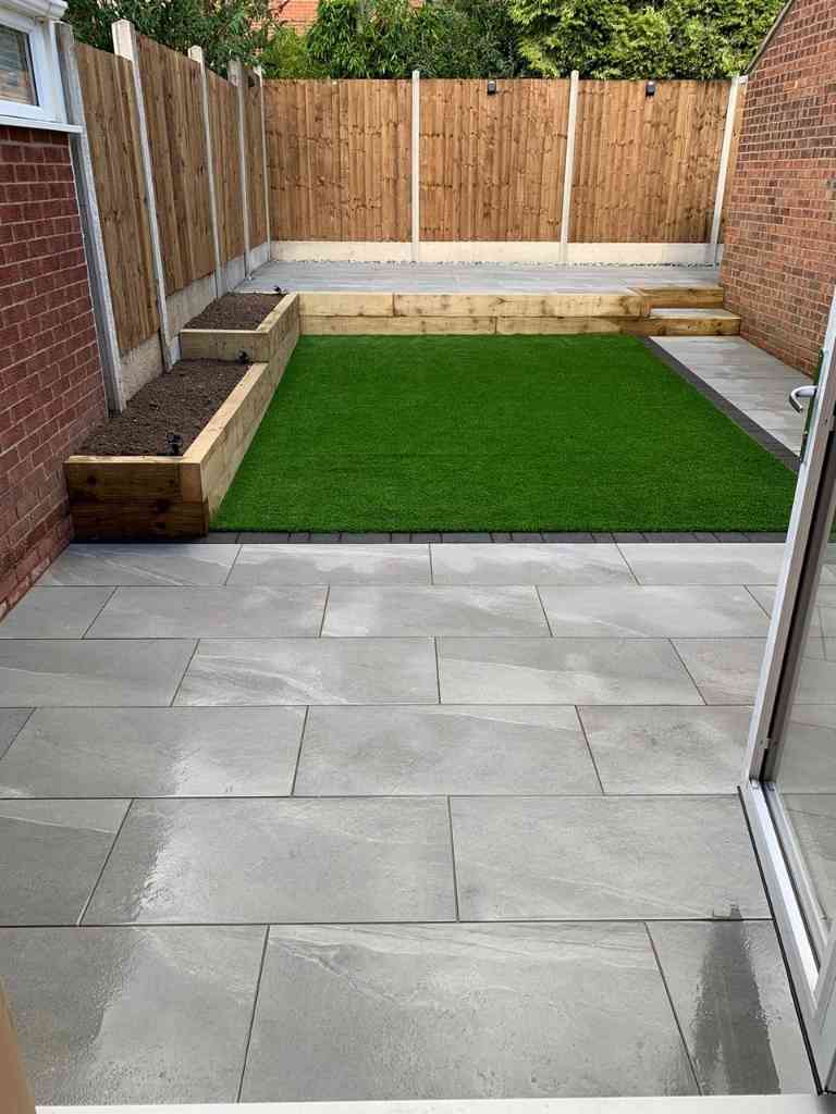 Low maintenance garden with outdoor porcelain terraced patios, artificial lawn and timber sleeper raised planting beds in Kenilworth, Warwickshire - Oakland Group.