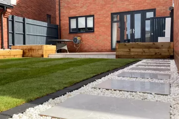 New build garden with contemporary outdoor porcelain pathway, new lawn, block edging and timber sleeper planting beds built around porcelain patio.