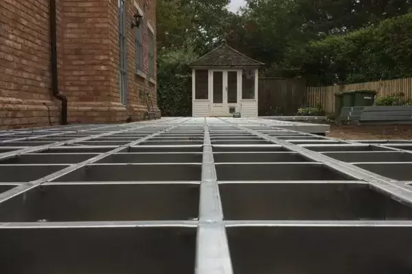 Large porcelain patio sub frame system installed over existing ground.