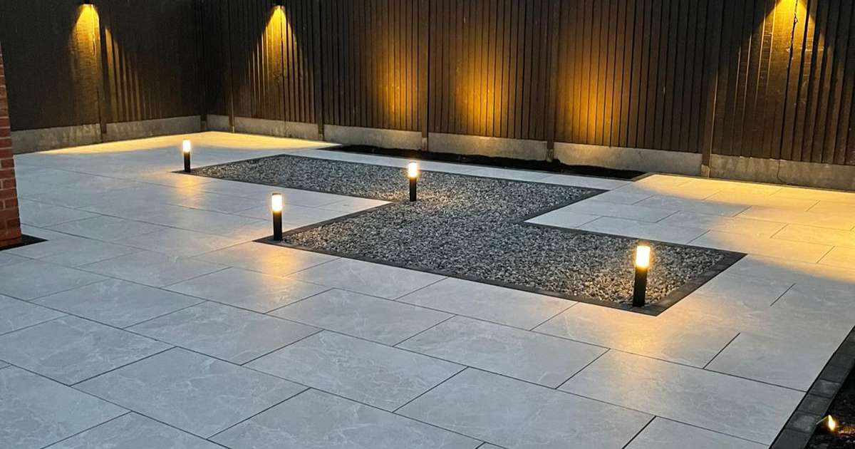 Professional landscaping works completed contemporary porcelain patio with block edge, and low voltage outdoor lighting installed - Oakland Group, Landscaping Services.