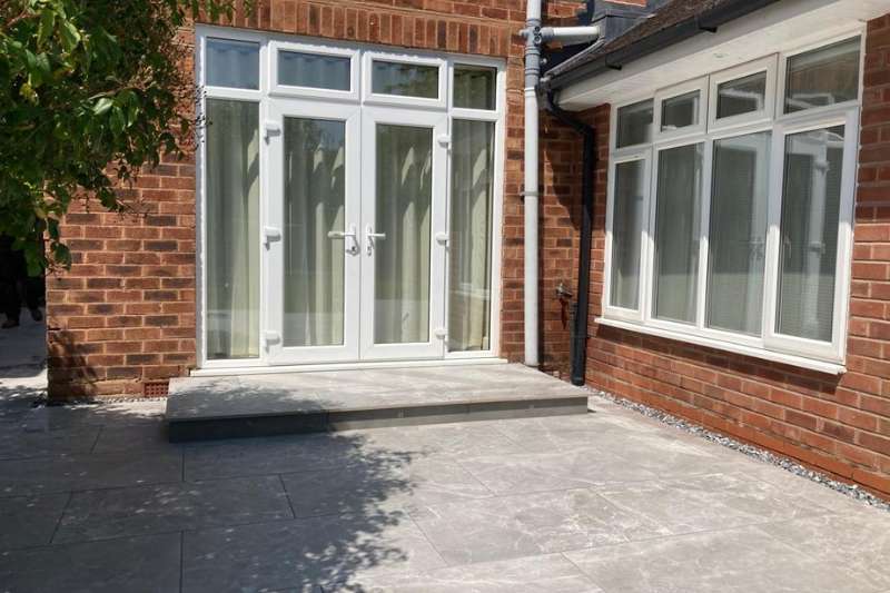 Landscaping works in Dorridge, Solihull. New porcelain patio build completed with low voltage outdoor lighting integrated in patio build project. Prima porcelain outdoor tiles. Main patio consists of 2cm Marble Light Grey 60 x 90cm. in-lite HYVE 22 RVS 12v outdoor decking lights recessed in step risers.
