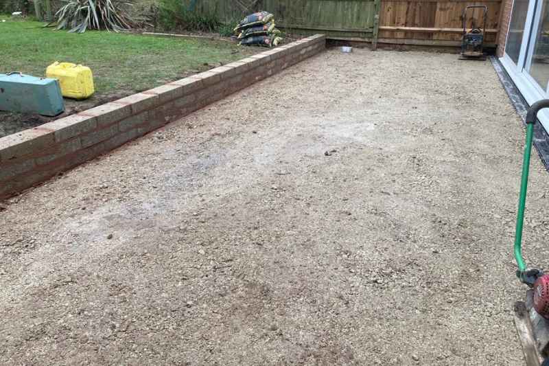 Patio landscaping works in Solihull. Patio build preparation for sub base and new wall.