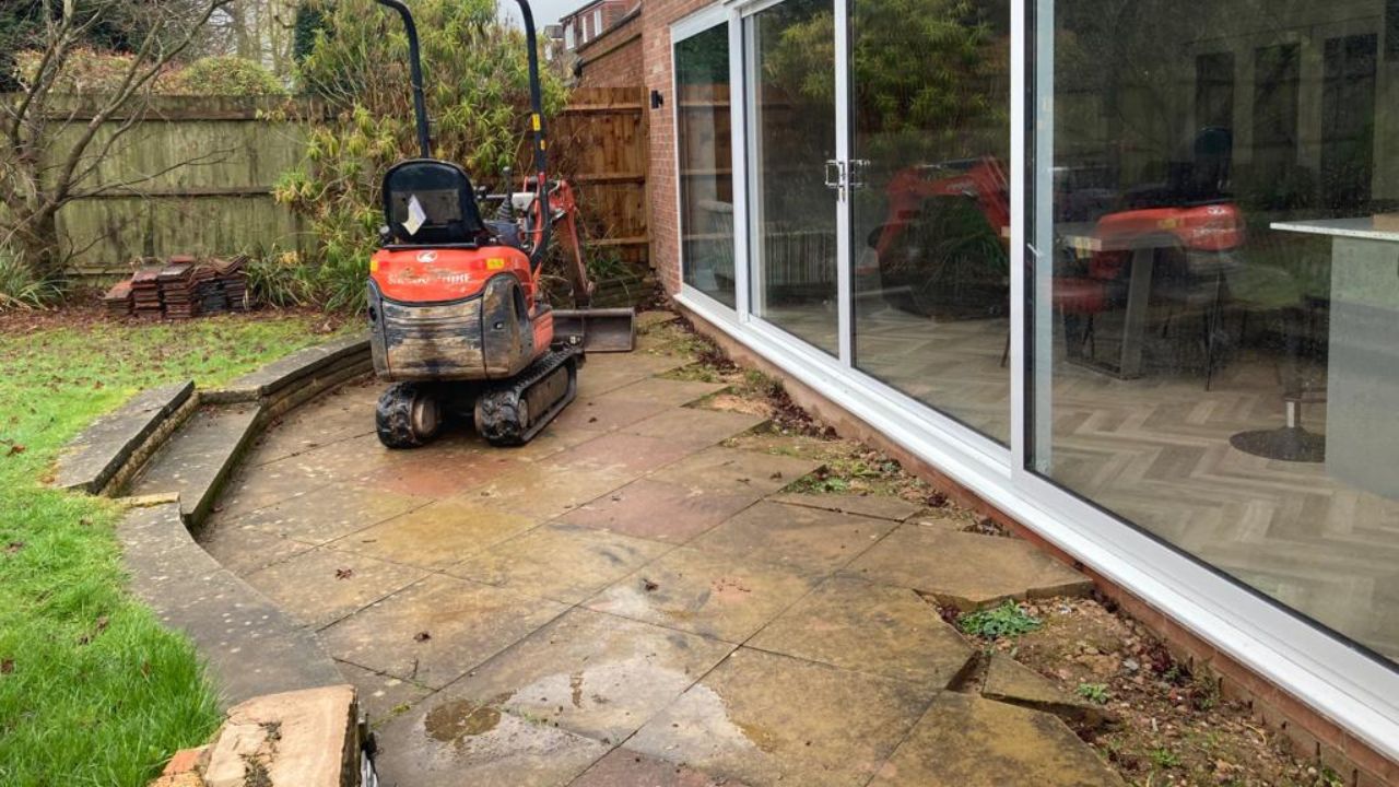 Landscape garden before landscaping works in Solihull. Mini digger in situ on old patio in rear garden.