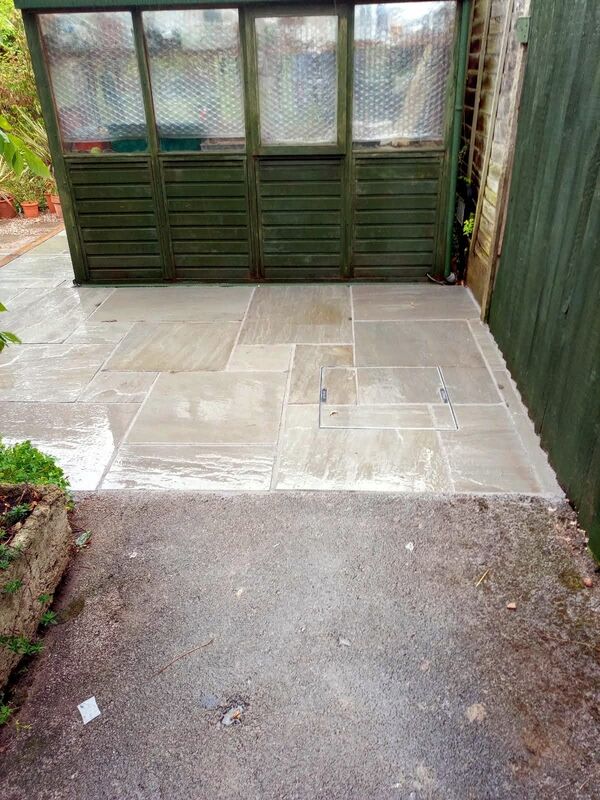 Landscaping works completed in Solihull. New patio laid with natural stone paving around green house.