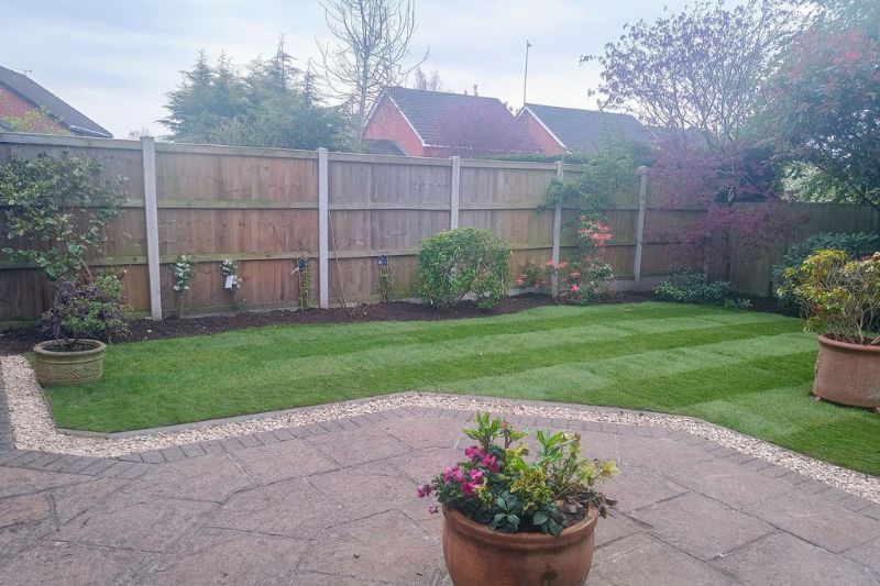 Landscaping works in Hatton Park, Warwick. New turf laid. Patio border created and decorated with stone chippings between turf and patio borders. Sandstone Twist and Sphere 80cm Natural Stone Water Feature installed.