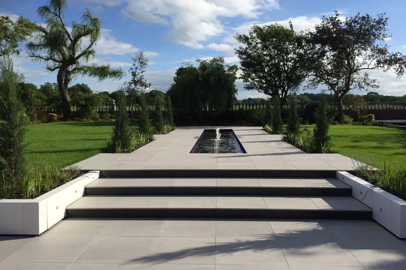 Large countryside landscape garden project with outdoor porcelain patio, steps, walkways and water fountains installed using the iGarden light steel subframe foundation system.