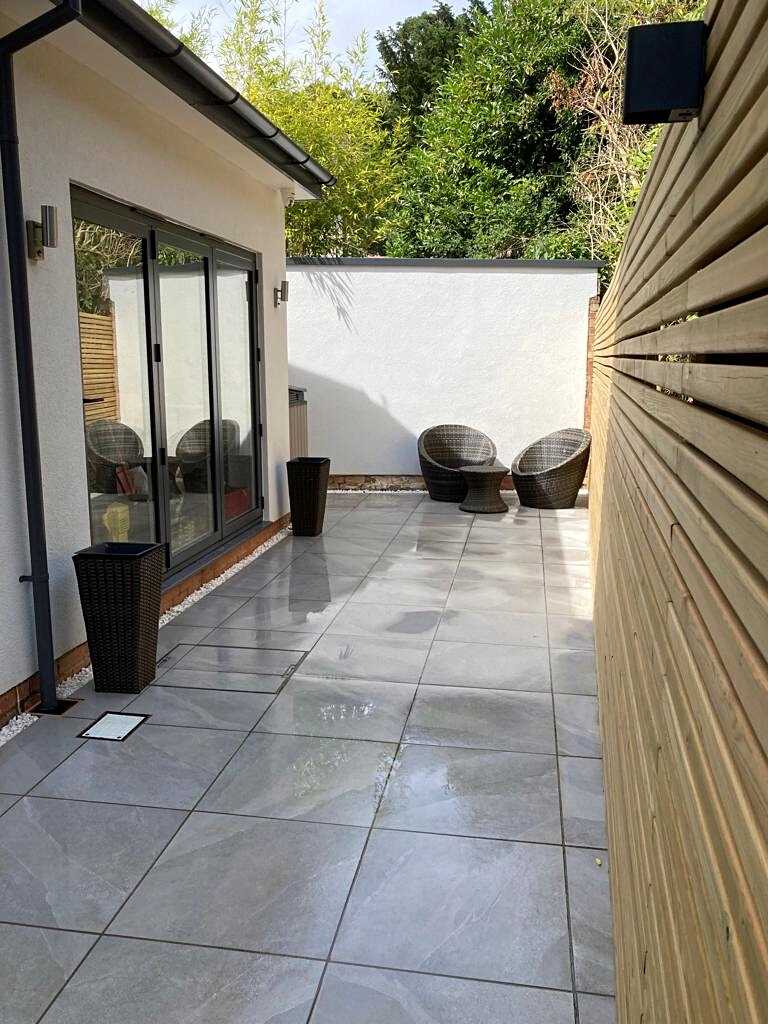 Contemporary new build home extension with porcelain patio and low voltage lighting for luxury garden in Dorridge, Solihull - Oakland Group.