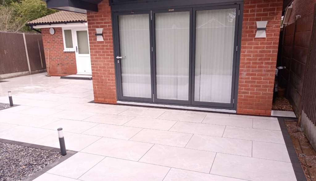 Contemporary new build home extension with porcelain patio and low voltage garden lighting for outdoor living space in Dorridge, Solihull - Oakland Group.