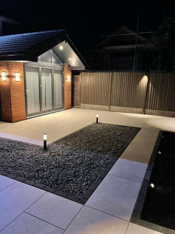 Contemporary new build home extension with porcelain patio and low voltage garden lighting during the evening in Dorridge, Solihull - Oakland Group.