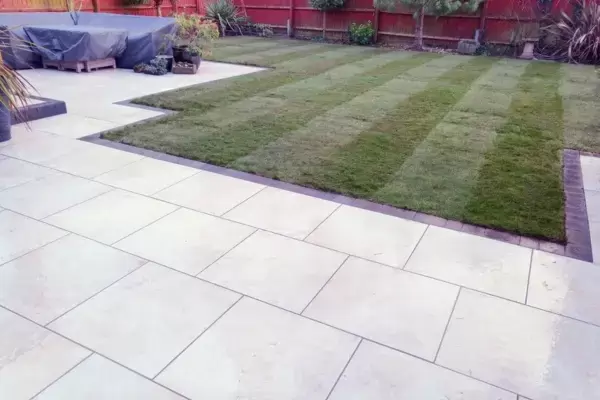 Porcelain patio with block edge  and turf lawn installed in rear garden.