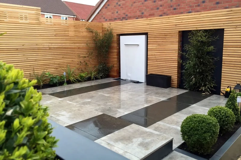 Low maintenance contemporary garden on split levels with outdoor porcelain, cascading water feature and slatted fencing installed using the iGarden light steel subframe foundation system.